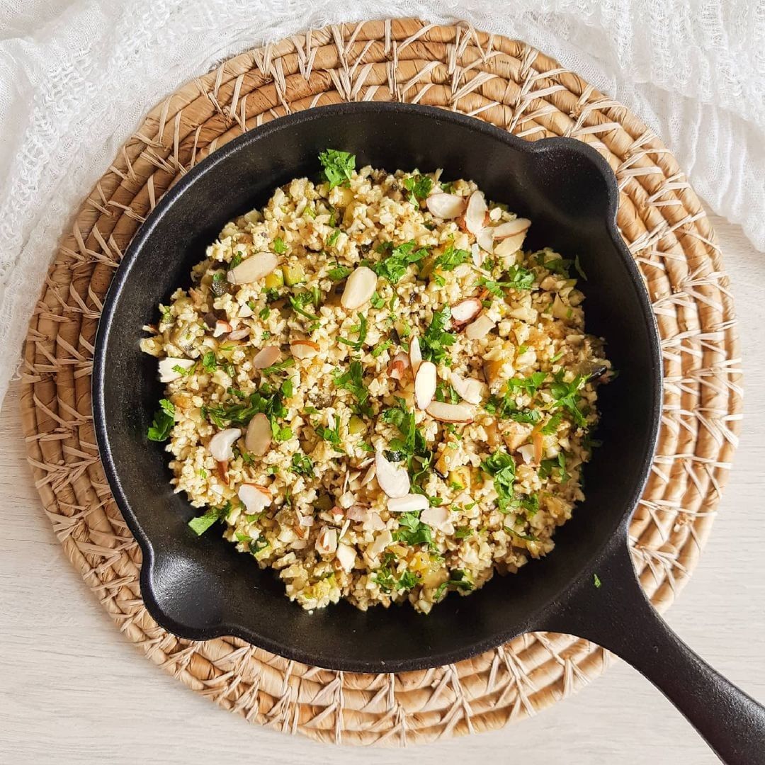 Arroz de coliflor con vegetales y nueces en hierro fundido.